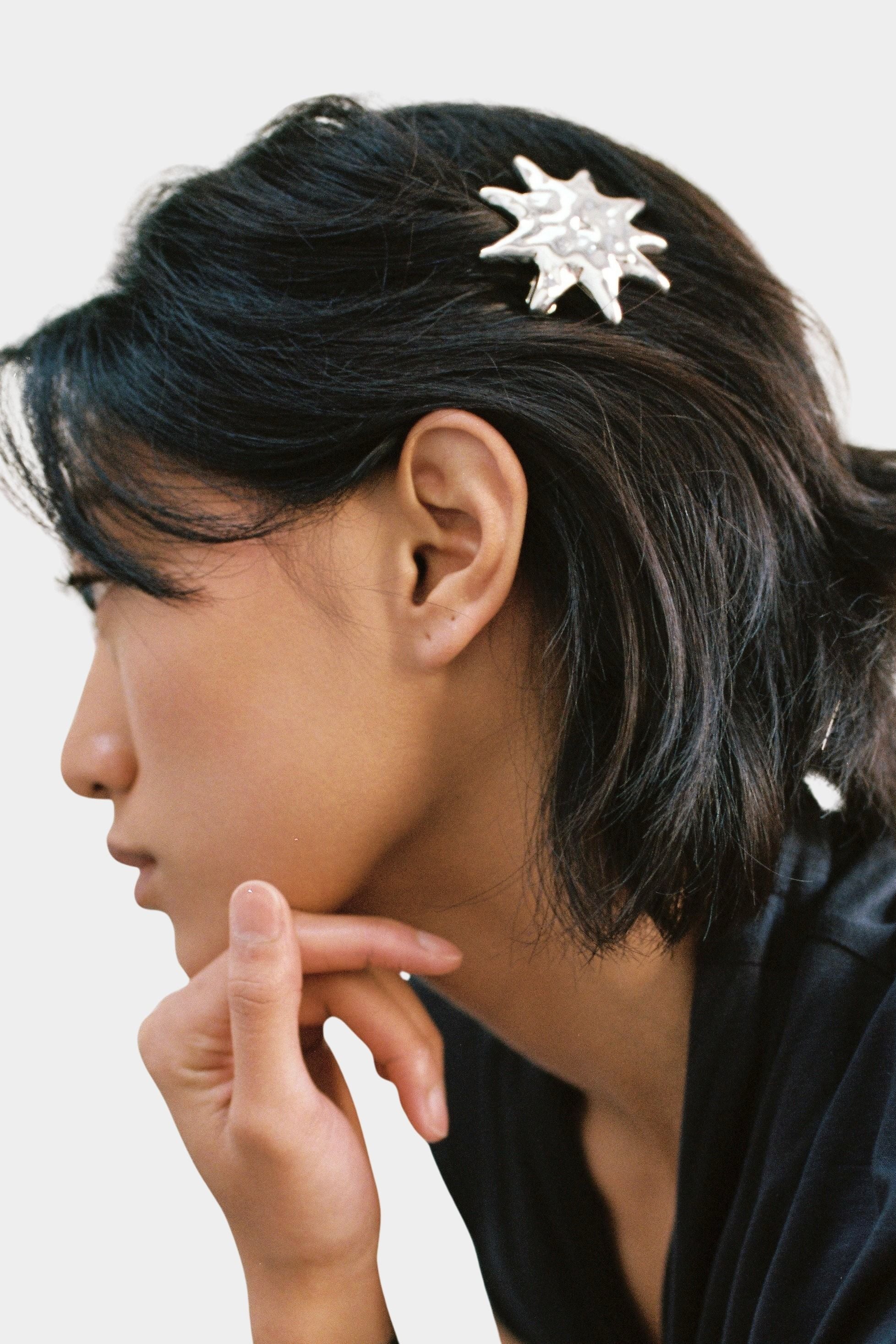 Silver sun shaped hair clip barrette side view holding hair back